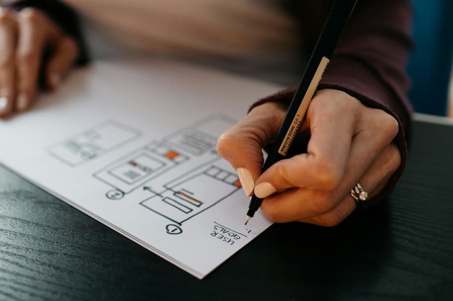 Diseñador web haciendo un boceto sobre papel.