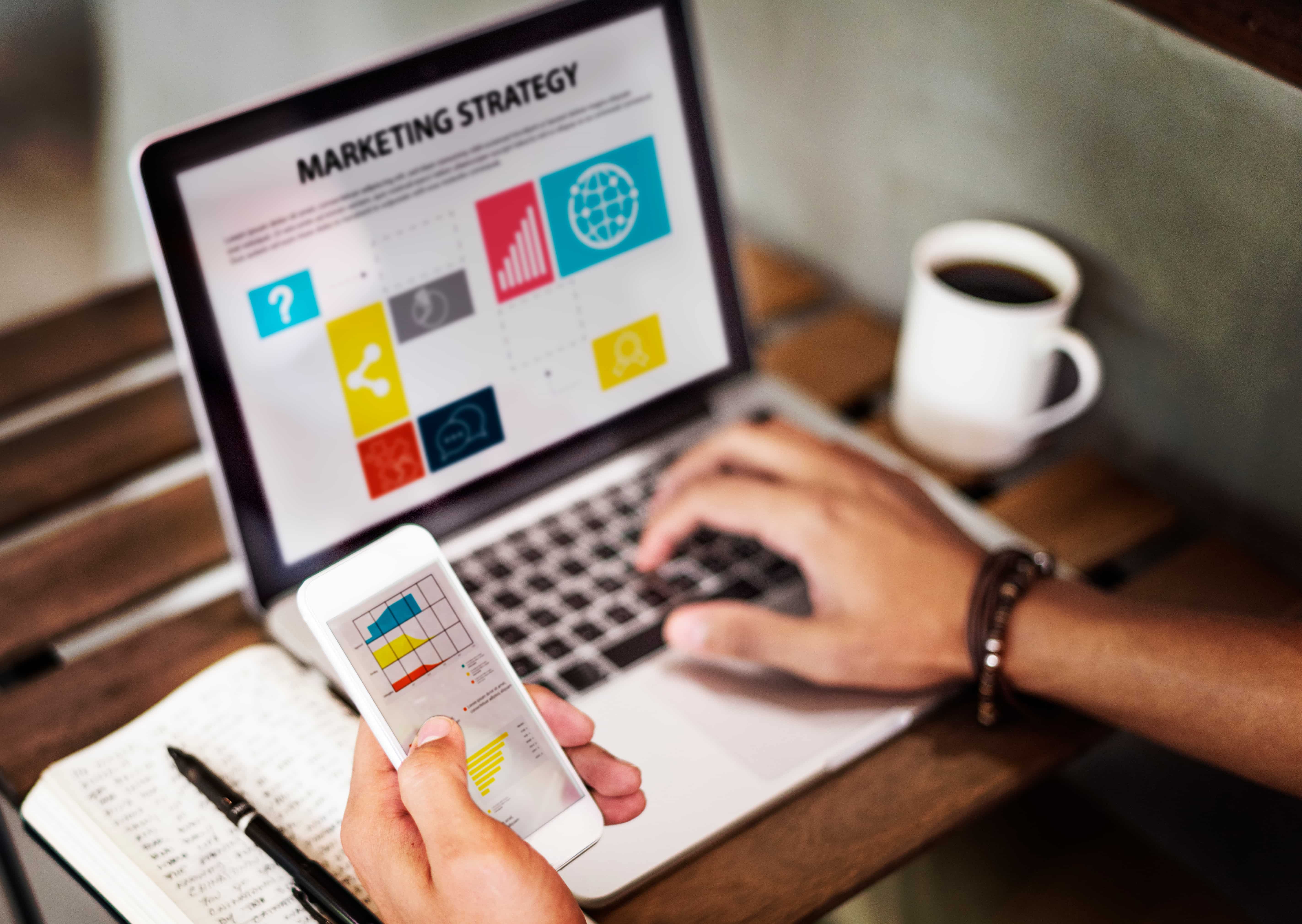Portátil y móvil con gráficas sobre marketing digital.